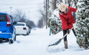 Woman Shoveling her Parking Lot after a Snowstorm